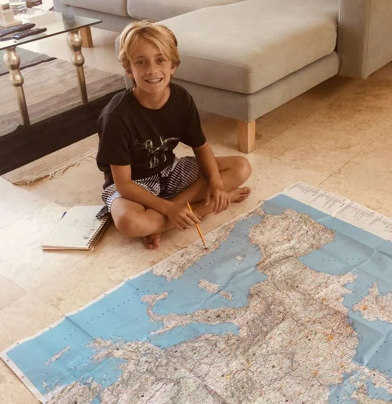 Young Maverick studying a world map
